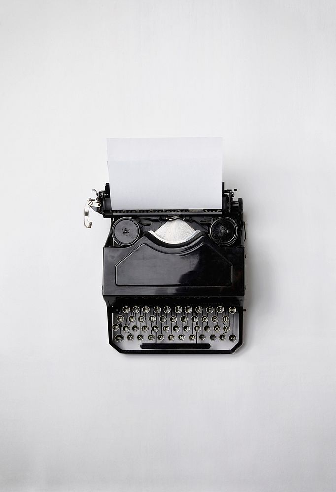 A vintage analogue typewriter with a white plain paper. Original public domain image from Wikimedia Commons