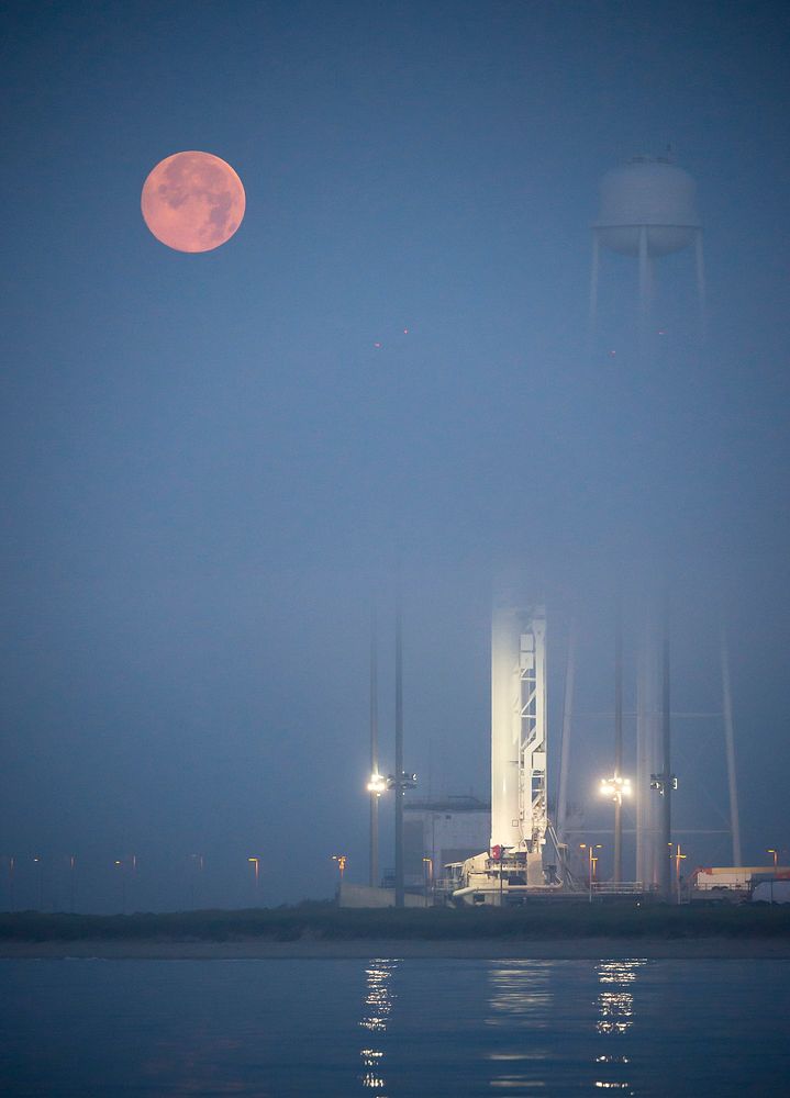The full Moon sets in the fog behind the Orbital Sciences Corporation Antares rocket. Original from NASA. Digitally enhanced…