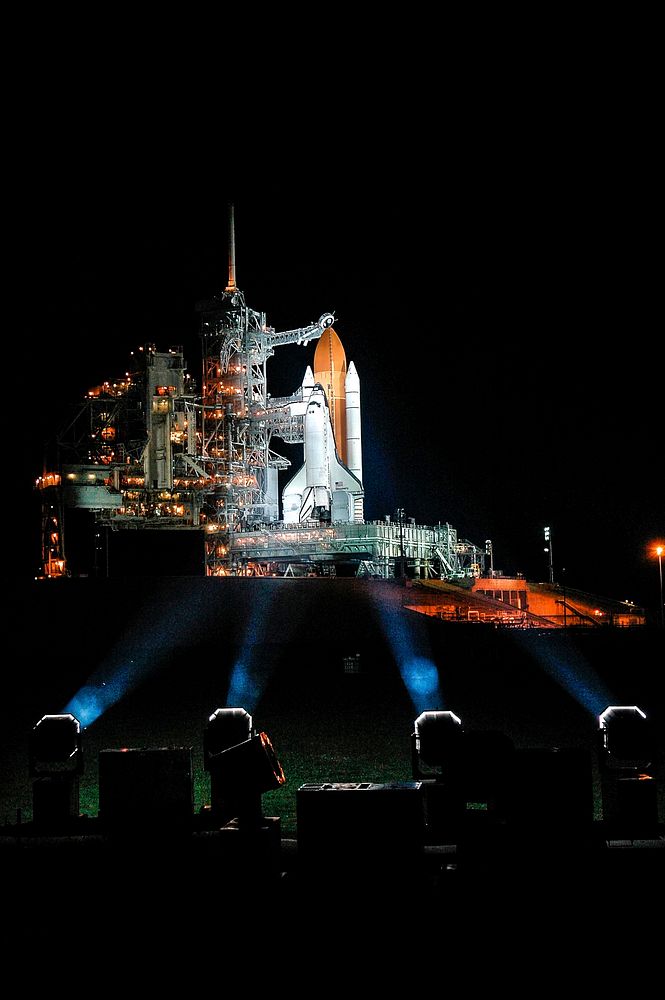 After rollback of the rotating service structure on Launch Pad 39B, Space Shuttle Discovery stands bathed in spotlights.…