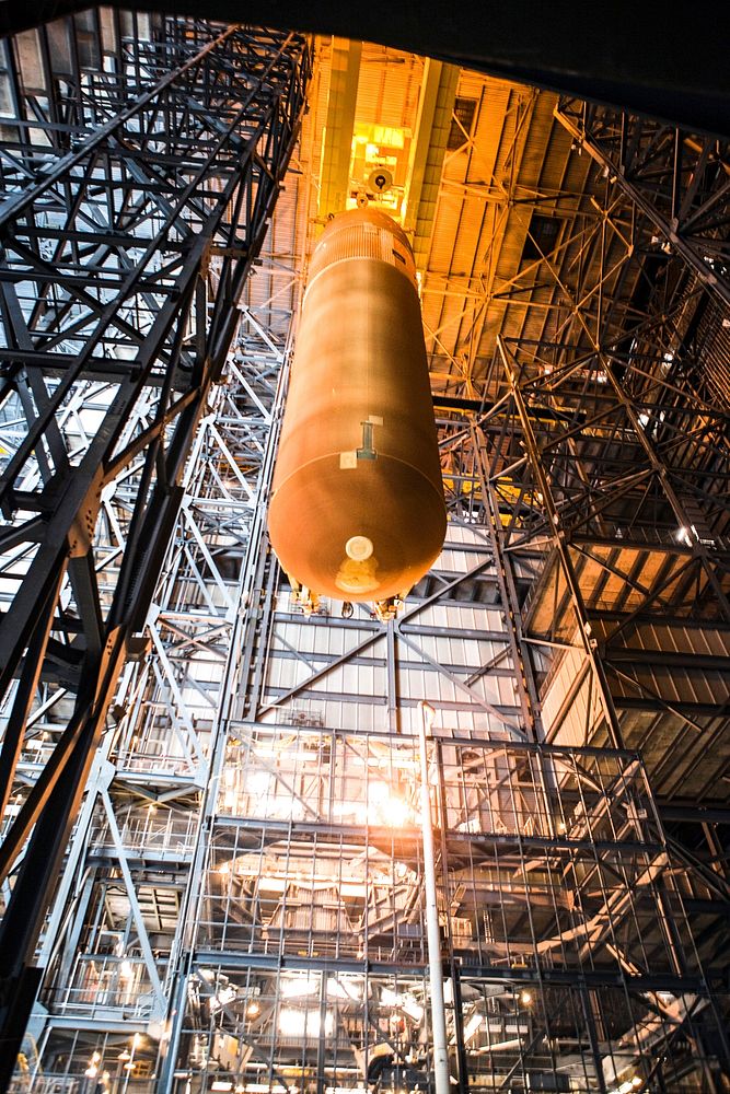 In the Vehicle Assembly Building at NASA's Kennedy Space Center in Florida, External Fuel Tank-122 is being lowered toward a…