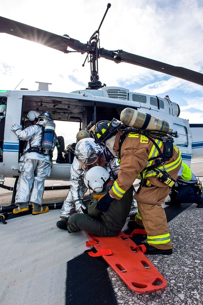 NASA Fire Rescue personnel assist volunteers portraying injured Huey II helicopter crew members participating in the…