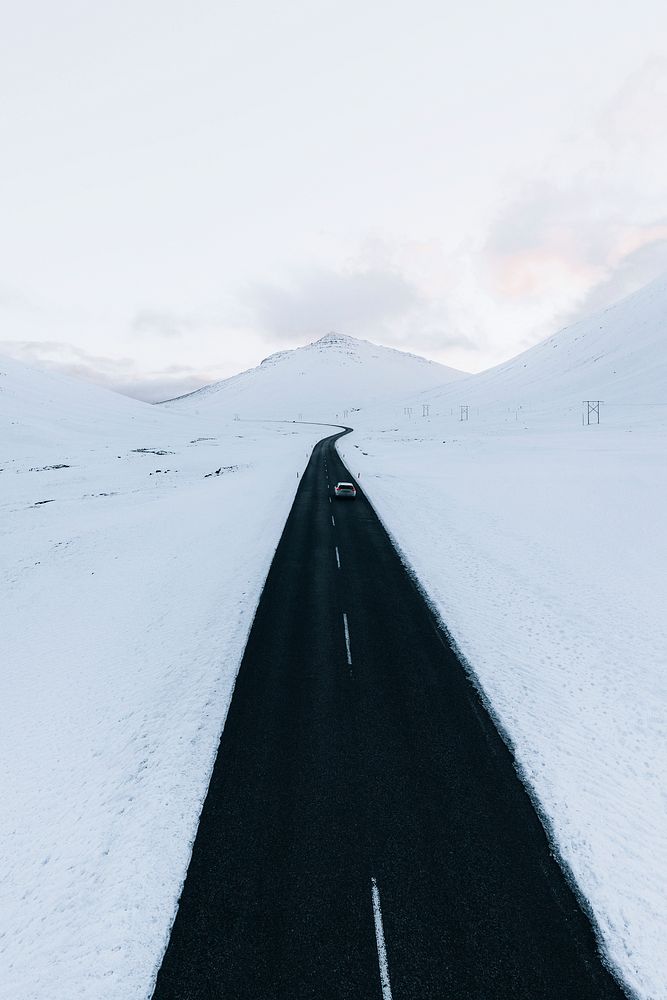 Long black road through the white winter landscape