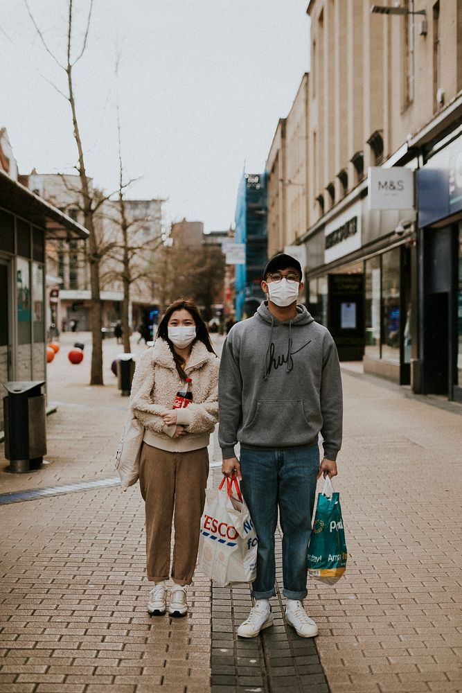 Couple with face masks while shopping in town during coronavirus pandemic. BRISTOL, UK, March 30, 2020
