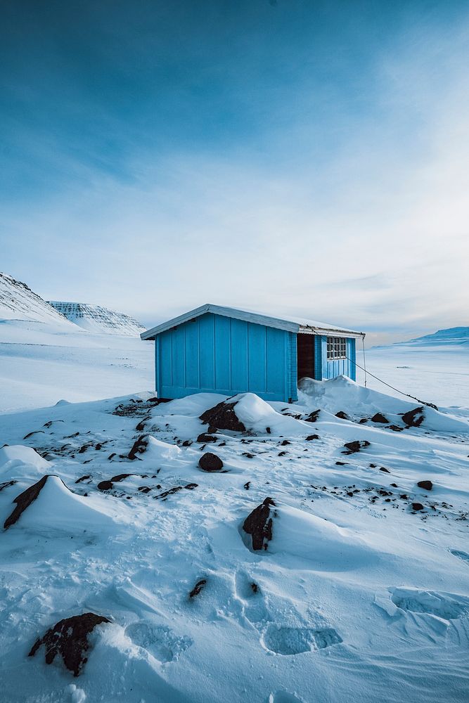 Blue abandoned wooden cabin in the snowy countryside of Greenland