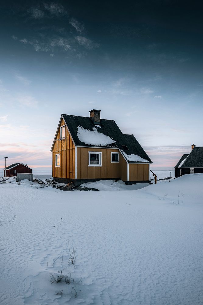 Yellow wooden house in the snow on Greenland