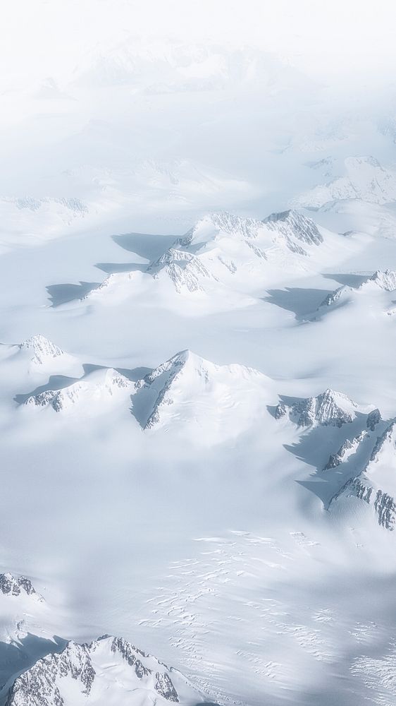 Drone view of a snowy mountain range in Greenland
