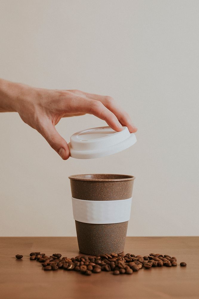 Hand opening a reusable coffee cup