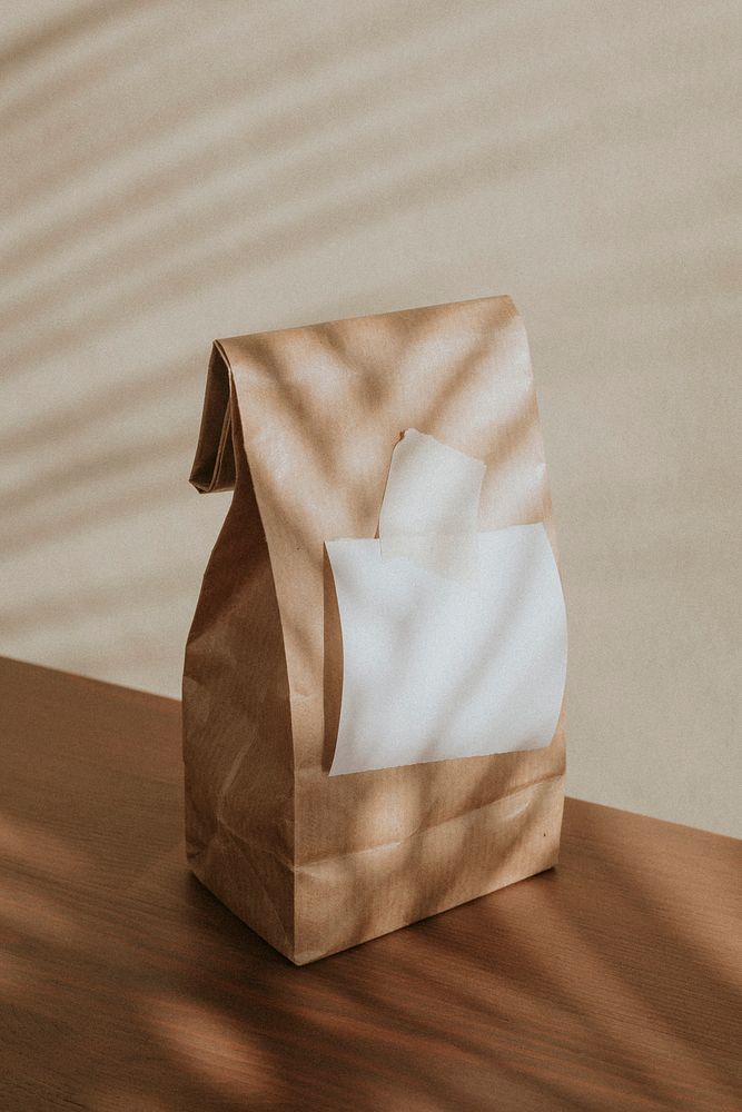 Brown paper bag with a blank white notepaper