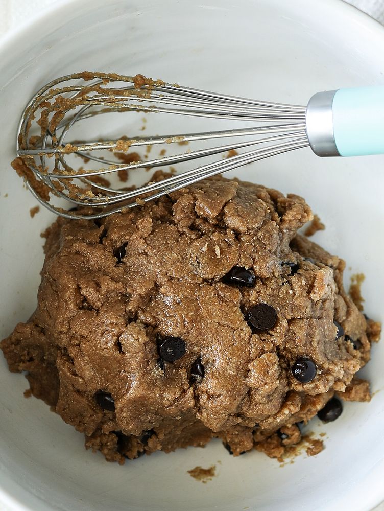 Chocolate chip cookie dough in a bowl with whisk