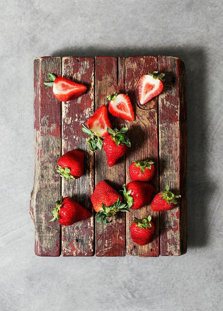 Freshly cut strawberries on a wooden board