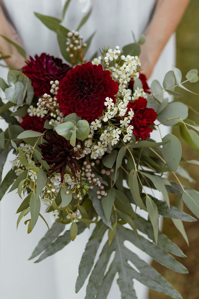 Bride holding a bouquet of red dahlia flowers
