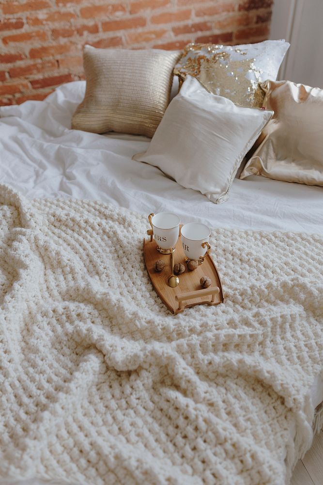 Wooden tray with coffee on bed