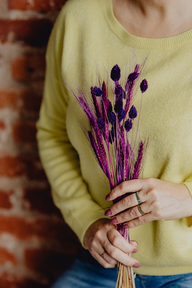 Woman holding a bundle of purple dyed wheat