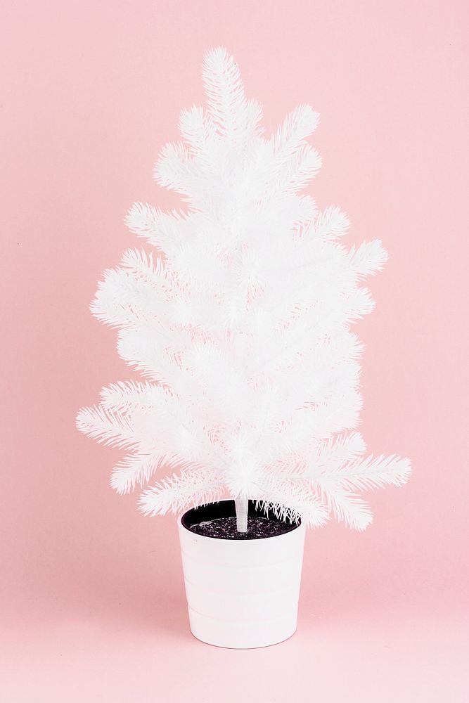 White artificial Christmas tree on pink background