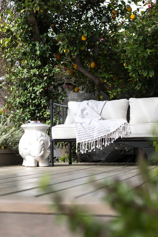 Outdoor wooden couch with white cushions