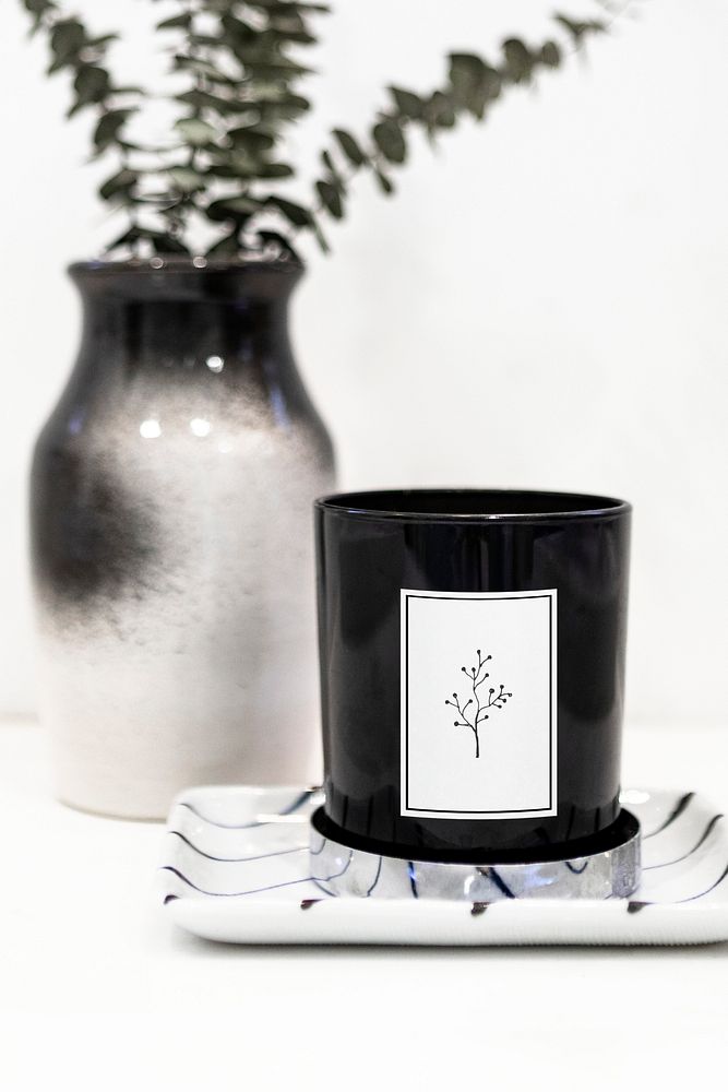 Black candle mockup by a vase