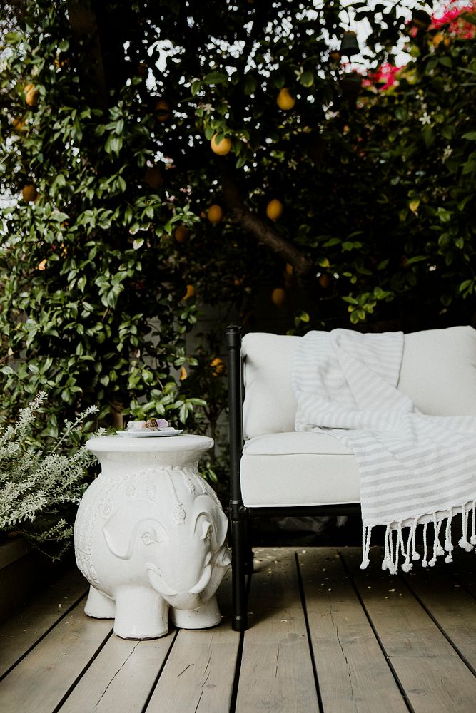 Outdoor wooden couch with white cushions