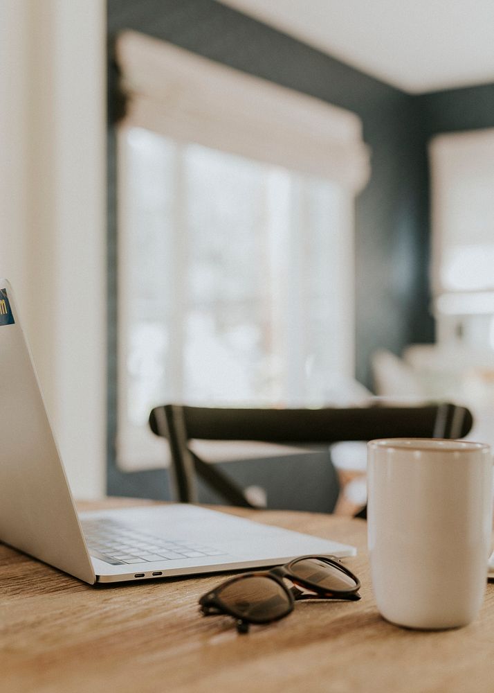 Laptop and coffee cup on wooden table