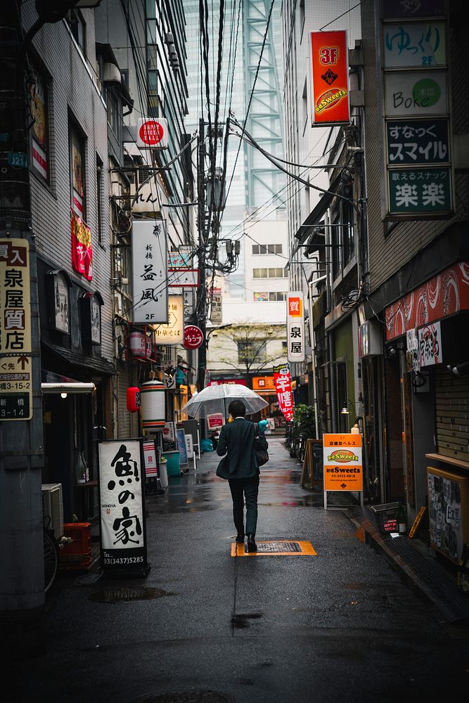 Japanese businessman walking under a transparent umbrella in Tokyo