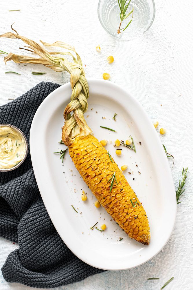 Fresh corn on the cob with organic rosemary leaves