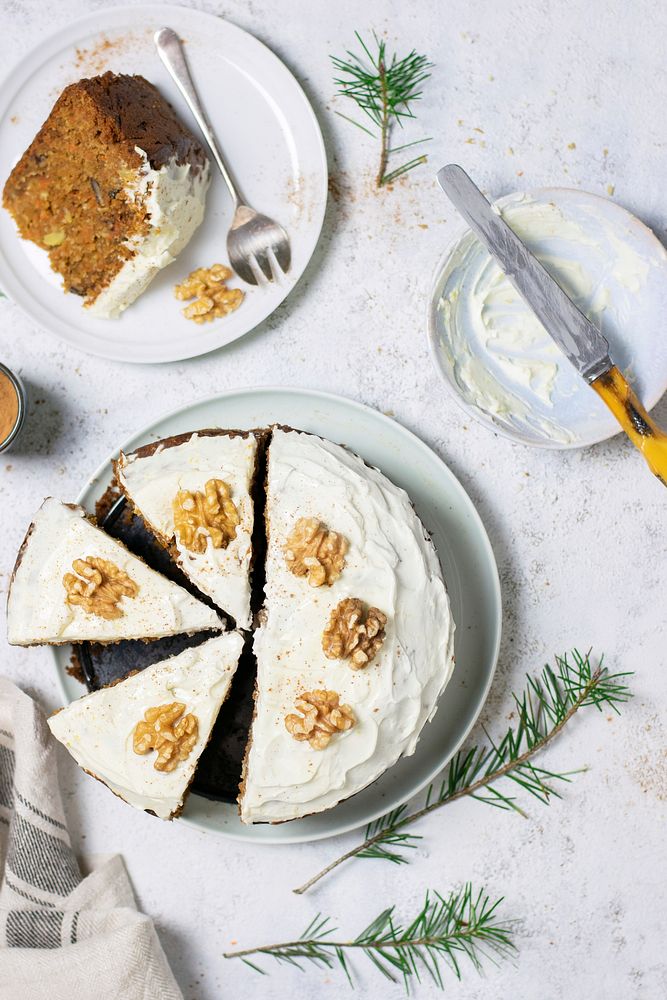 Sliced carrot cake topped with walnuts