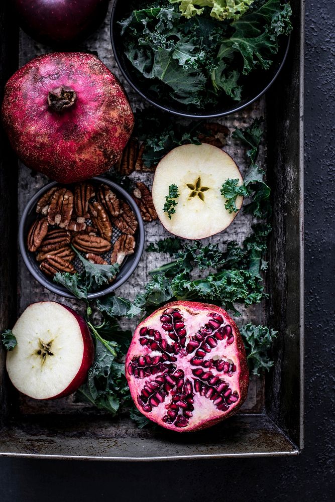 Fresh pomegranate with apples and pecans food photography