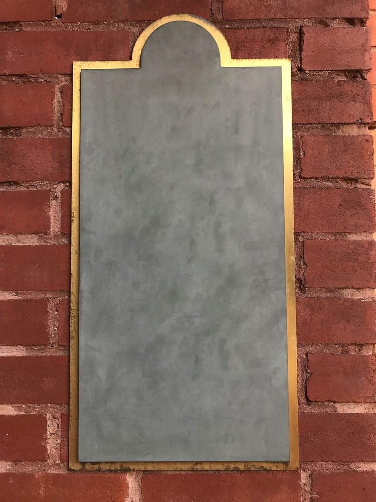 Golden frame against a brick wall