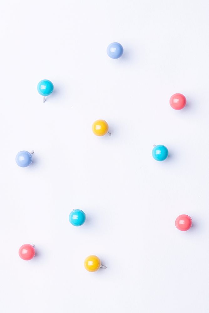 Minimal background, cute polka dot design, colorful push pins on paper