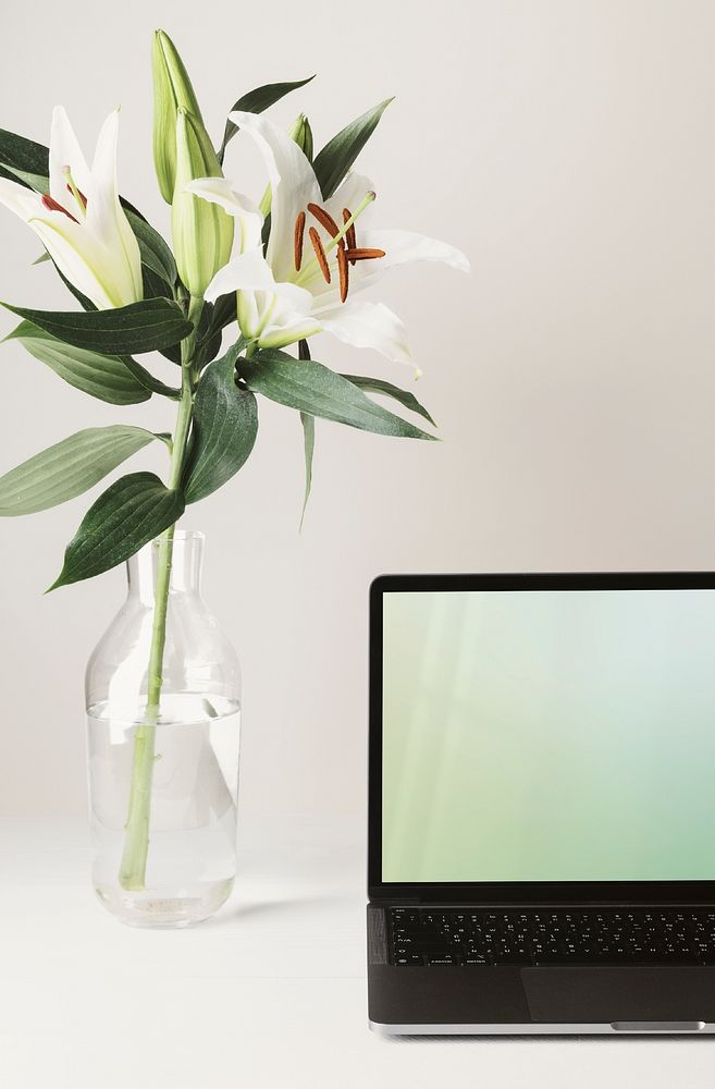 Minimal workspace with laptop and flower in vase