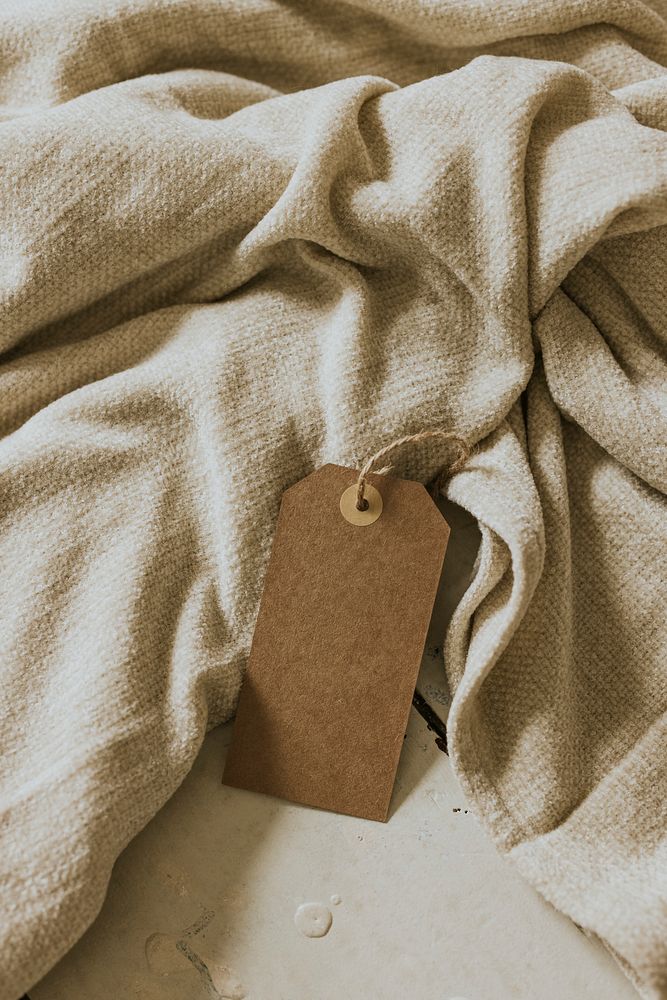 Blank paper tag on soft beige fabric