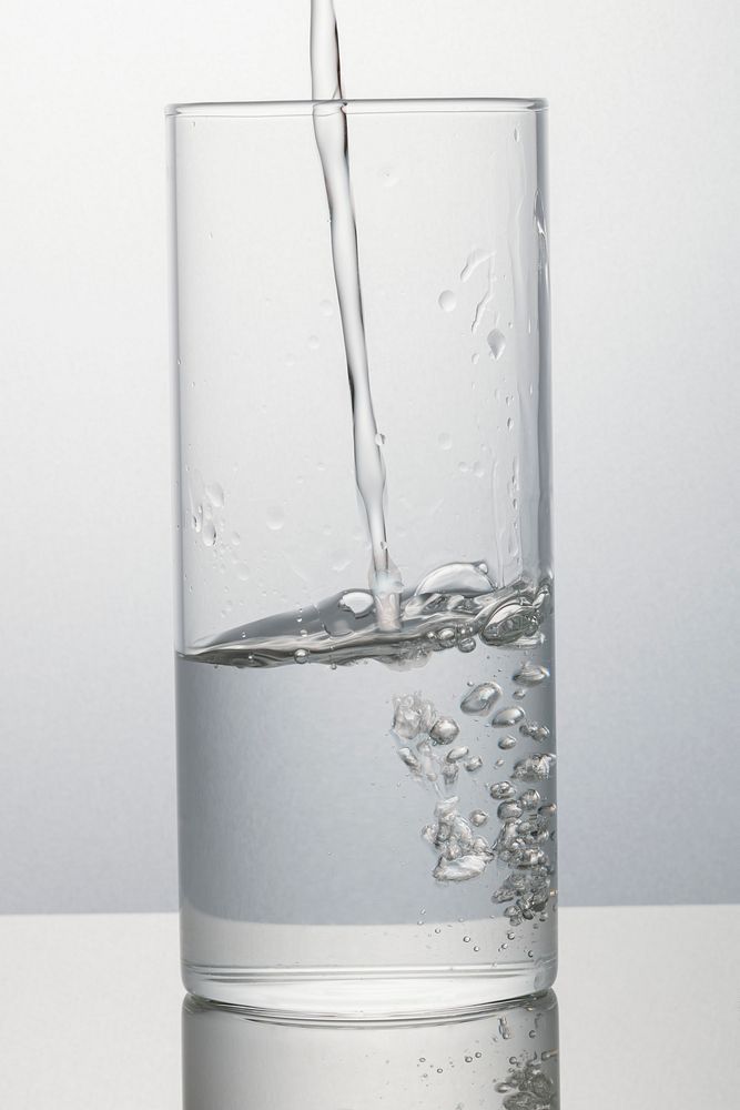 Macro shot of water pouring into a glass