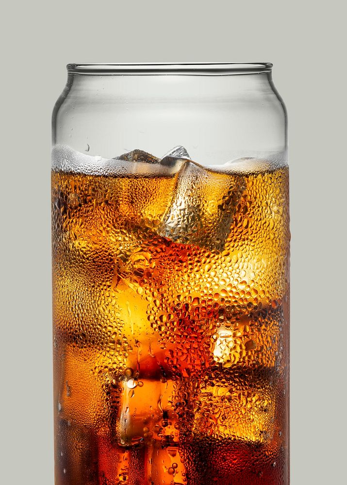 Cold carbonated drink over ice cubes in a can shaped glass 