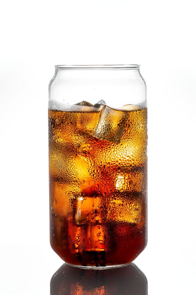 Cold carbonated drink over ice cubes in a can shaped glass 