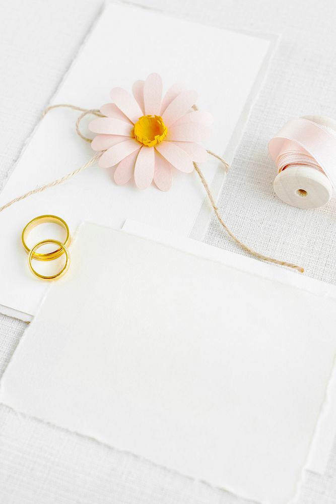 Blank white paper  with golden rings and a pink flower