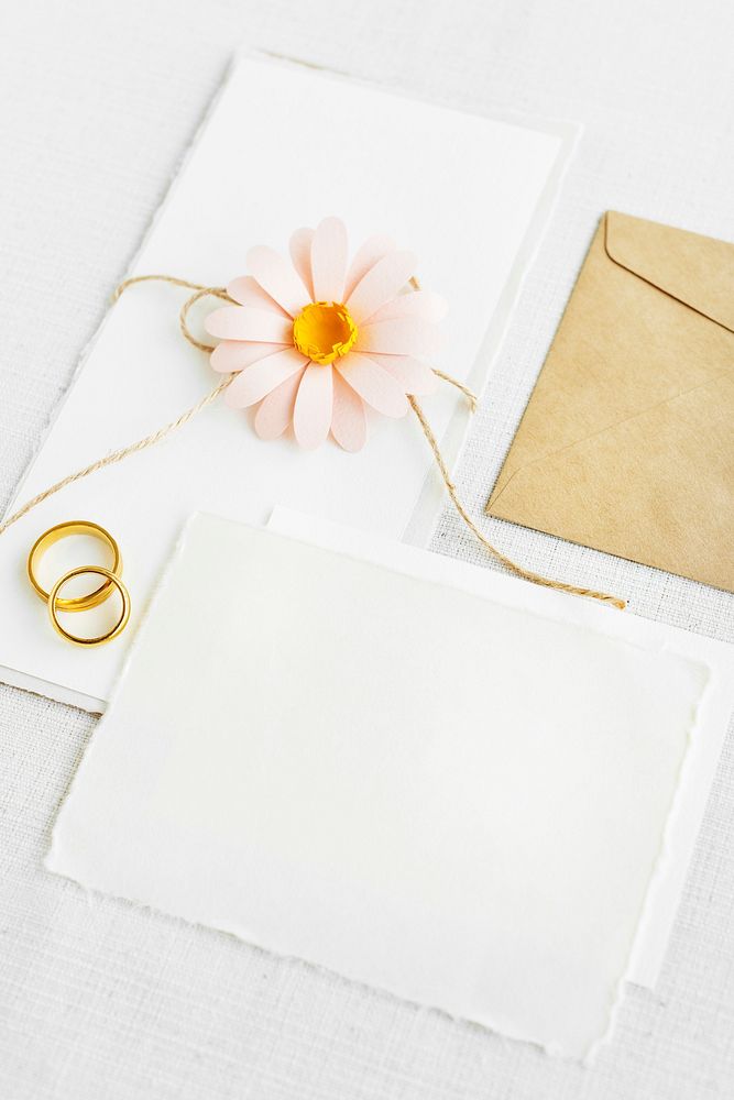 Blank white paper with golden rings and a pink flower