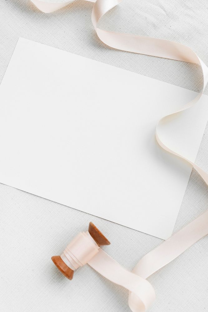 Blank white paper note with a pink ribbon roll