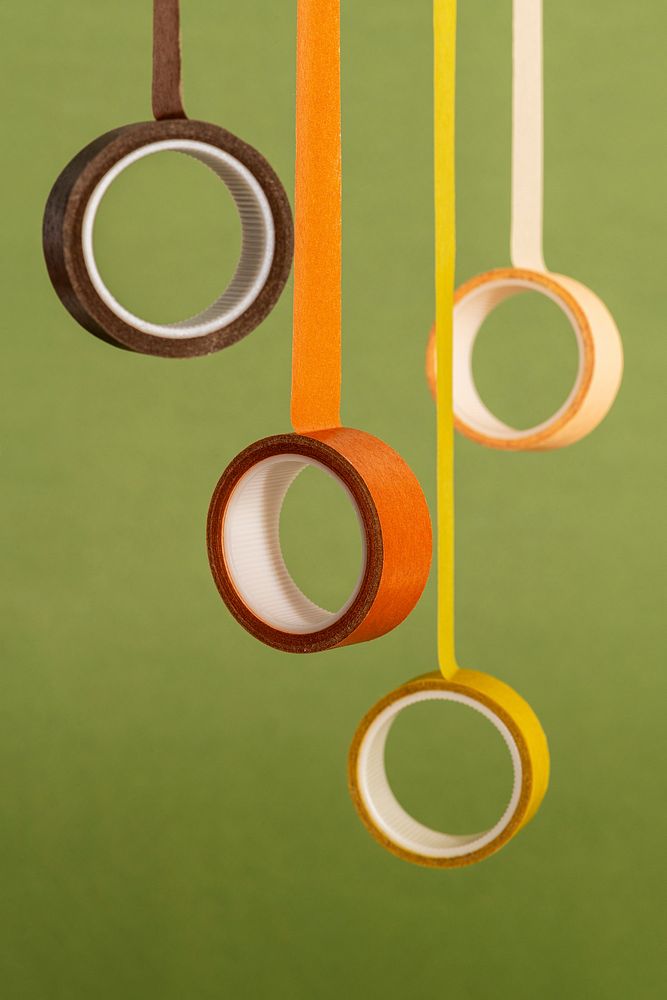 Yellow and orange rolls of tape on an olive green background 