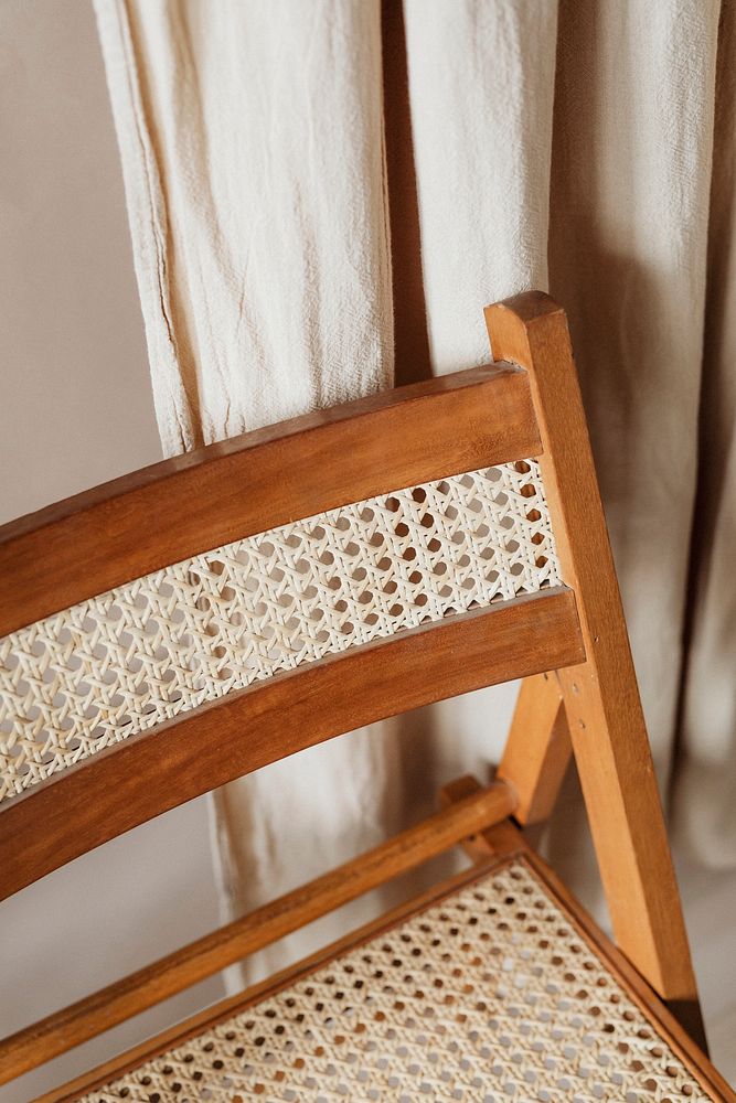 Homely wooden handicraft chair by a curtain
