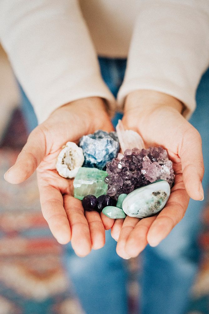 Woman with a hand full of healing crystals 