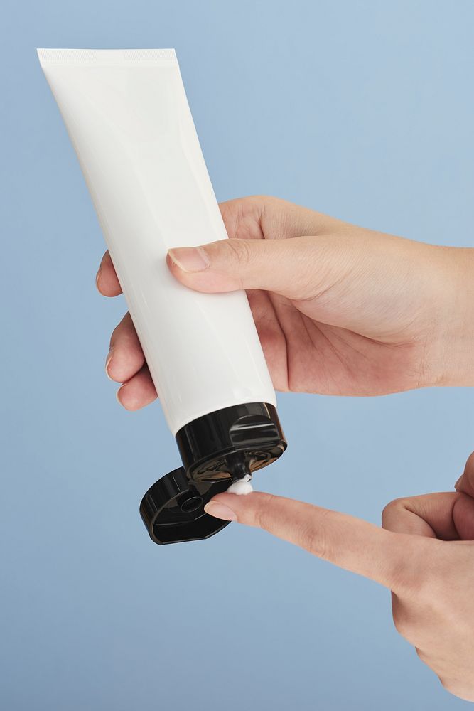 Woman squeezing cream from an unlabeled tube
