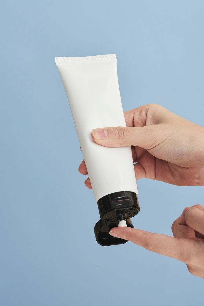 Woman squeezing cream from an unlabeled tube