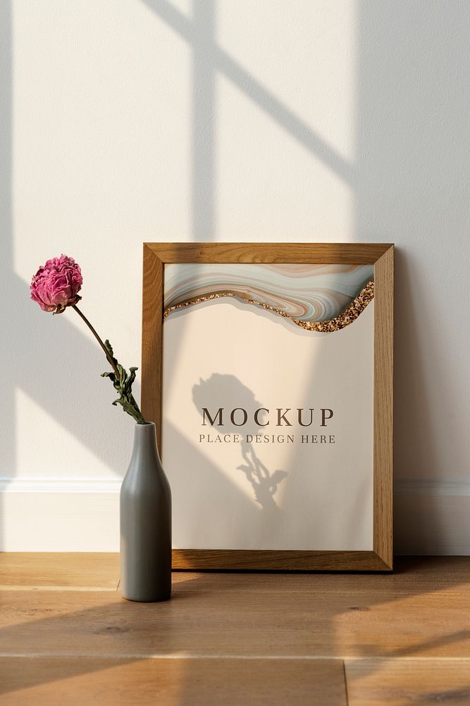 Dried pink peony flower in a gray vase by a wooden frame mockup on the floor