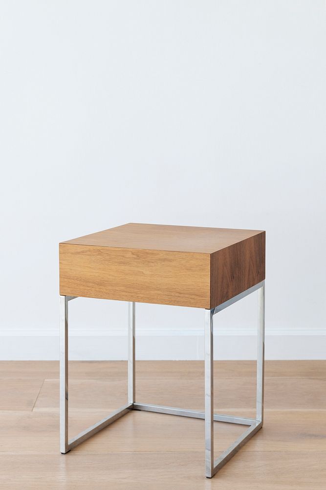 Square wooden stool with metal legs on a wooden floor