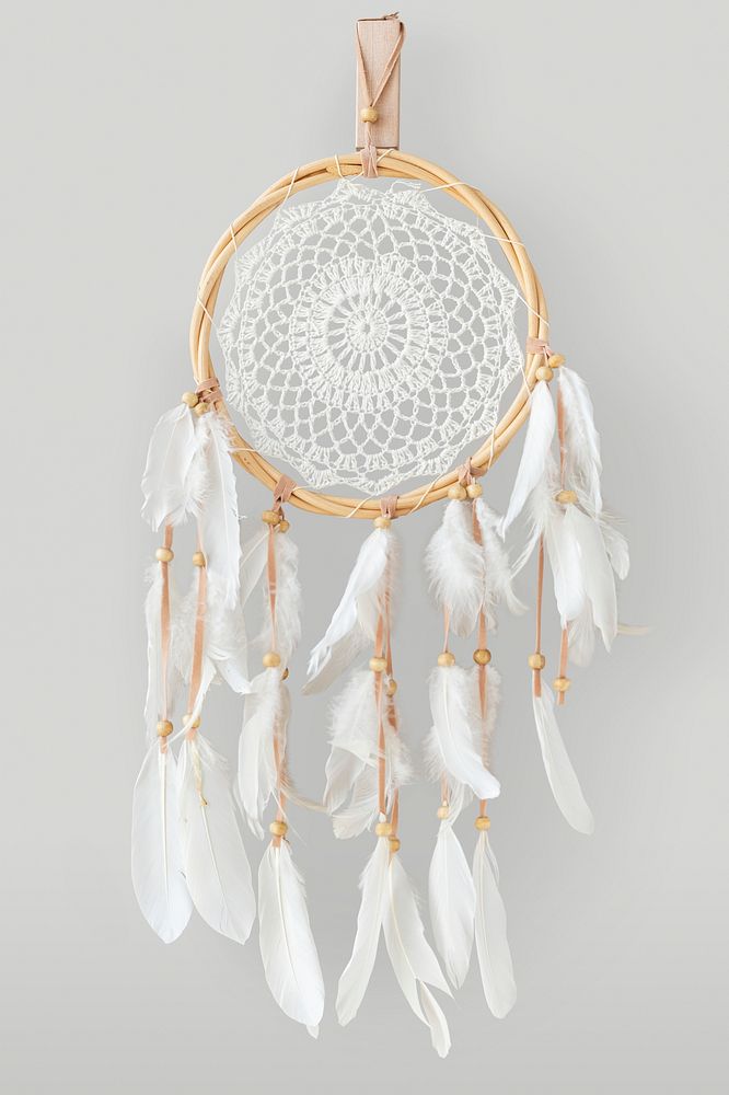 White dream catcher hanging on a off white wall
