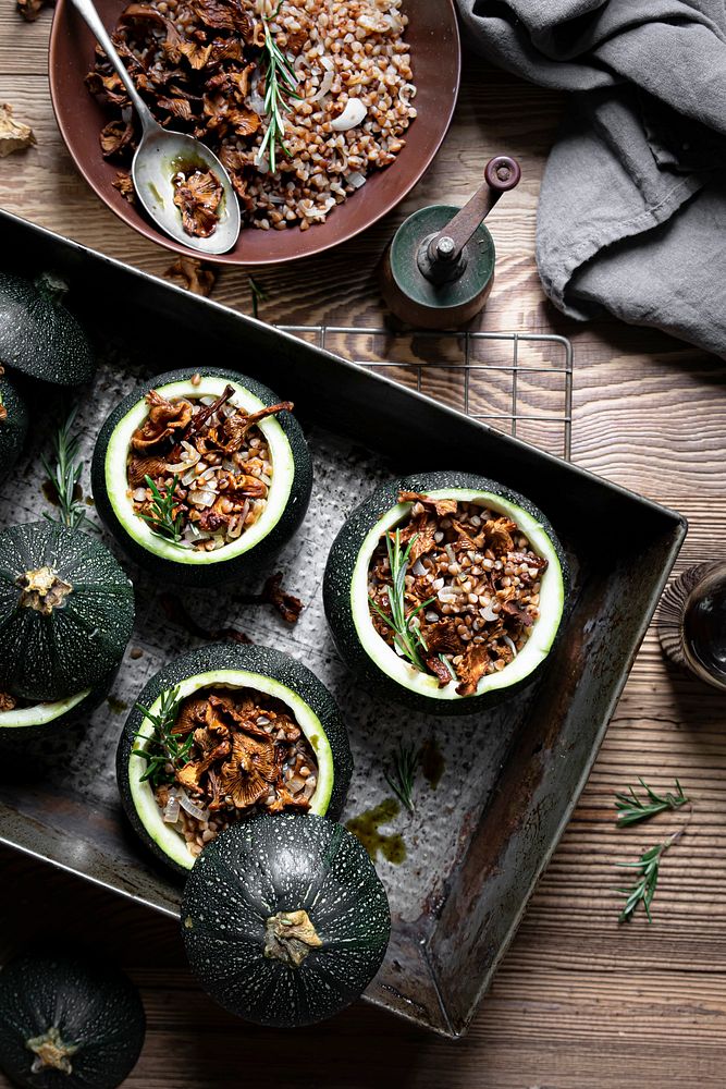 Delicious chanterelle stuffed round zucchini on wooden table