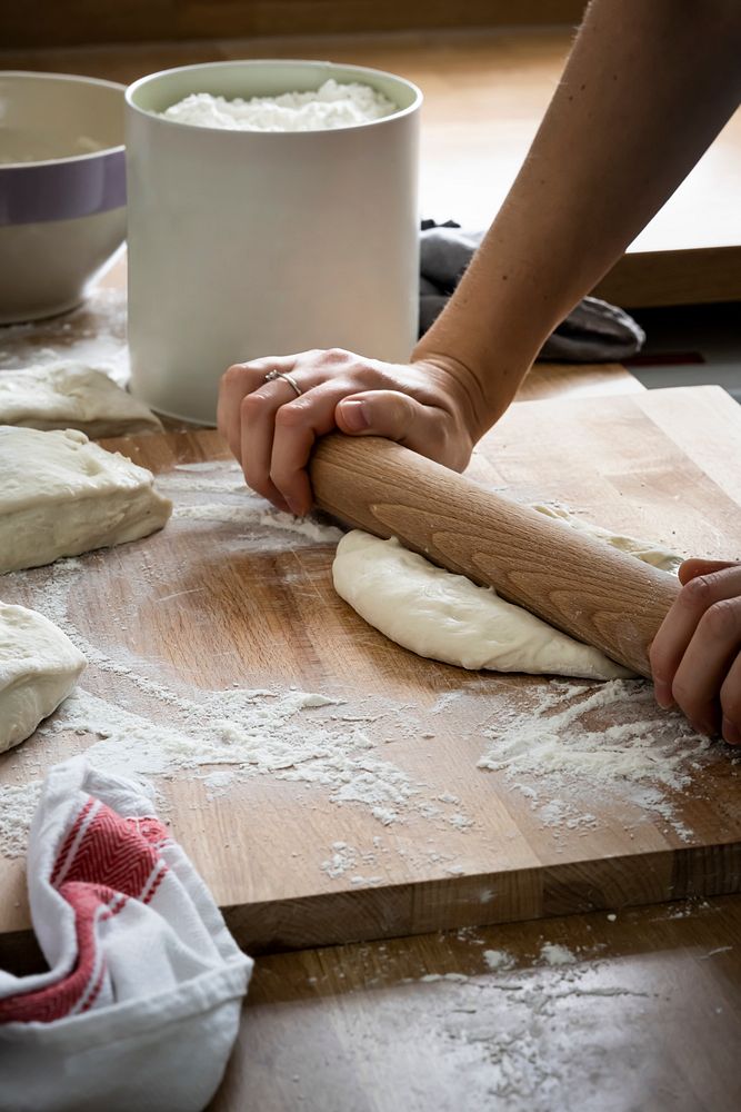 Baker kneading a dough in kitchen closeup
