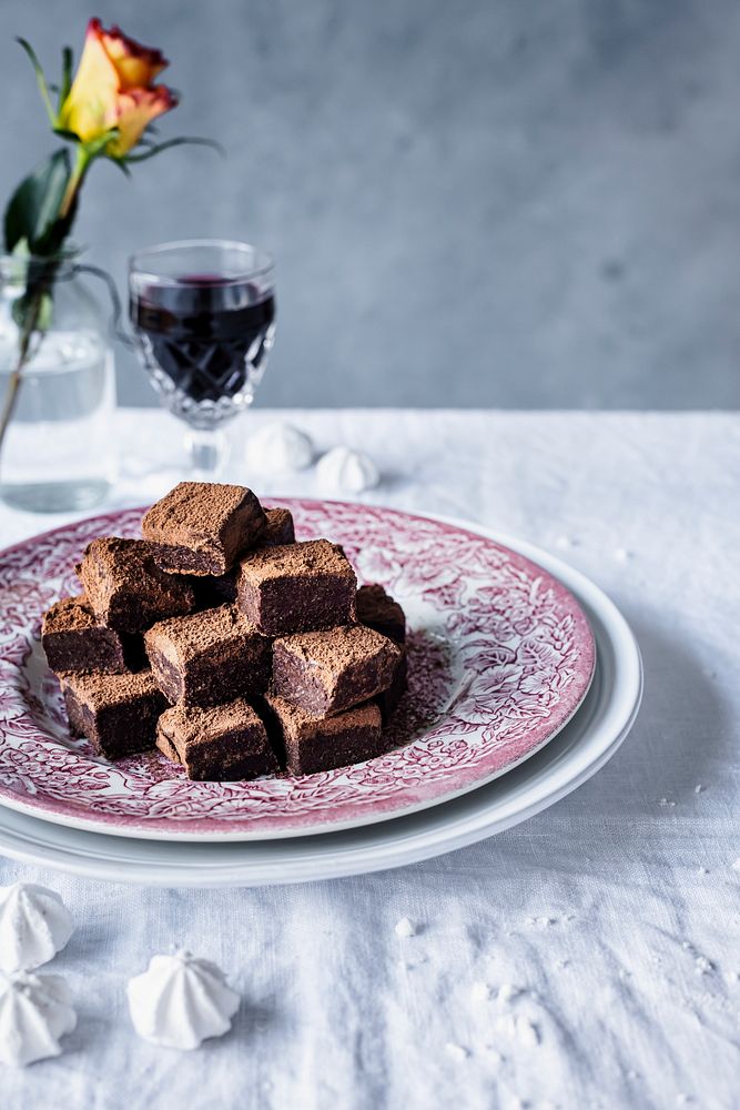 Chocolate ganache truffle squares dusted with cacao powder on a dining table