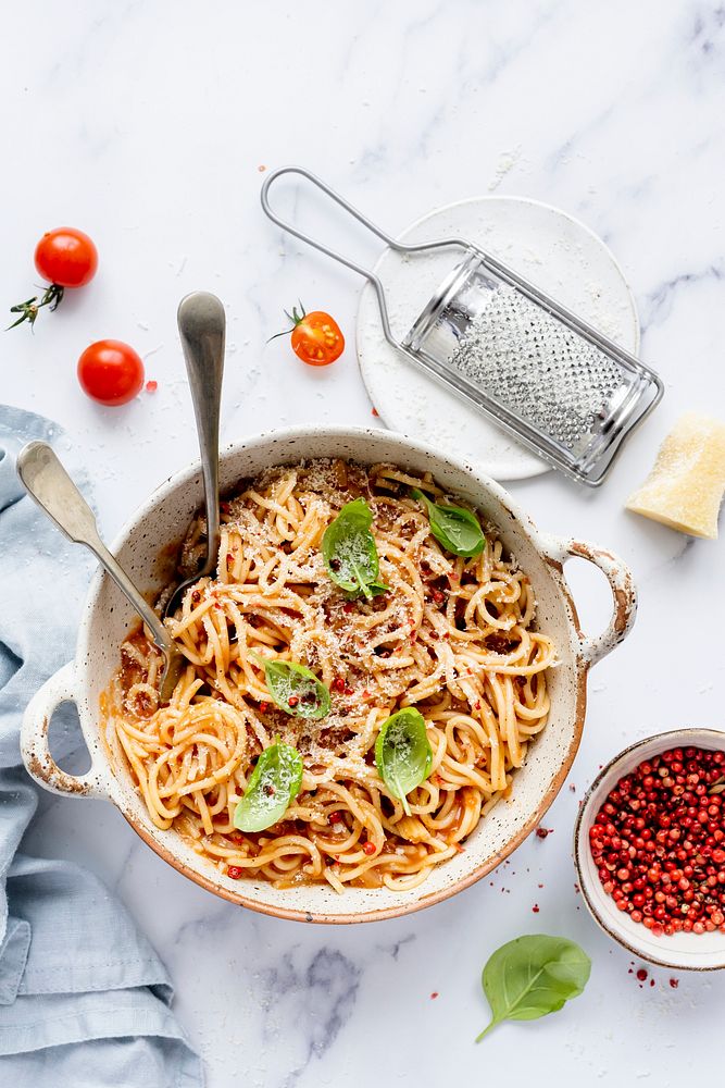 Spaghetti with marinara tomato sauce topped with parmesan and basil food photography