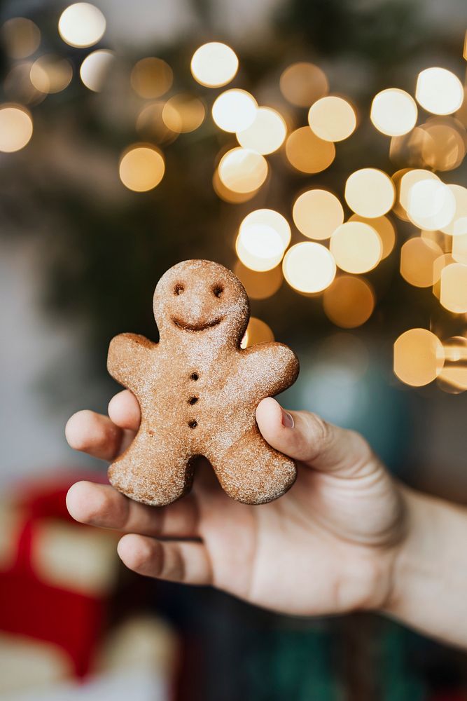 Man holding a gingerbread man cookie