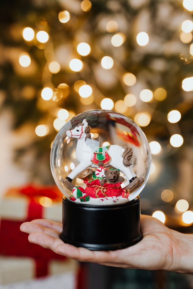 Christmas snow globe in her hand